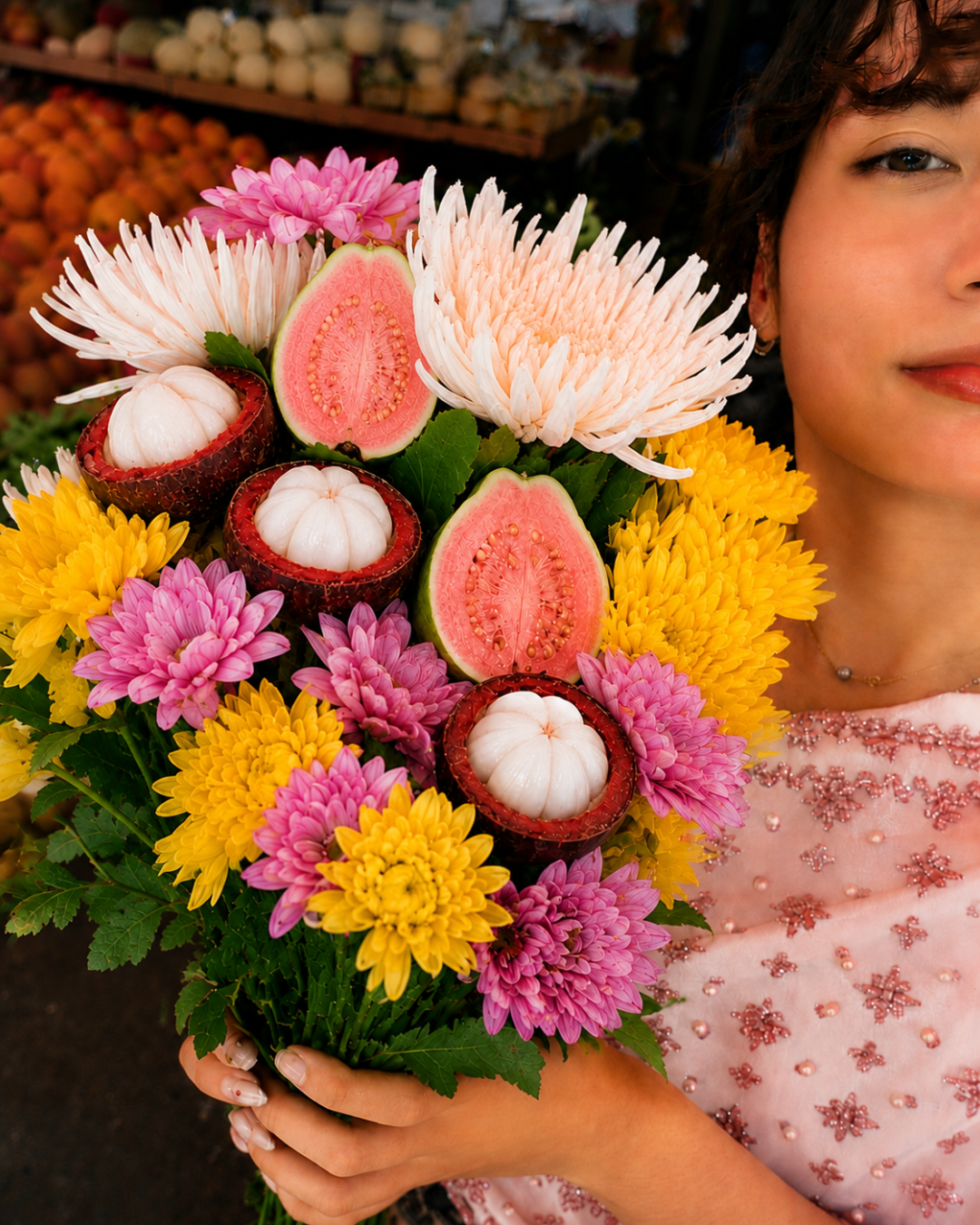 Bride holding a bouquet made from flowers and tropical fruit