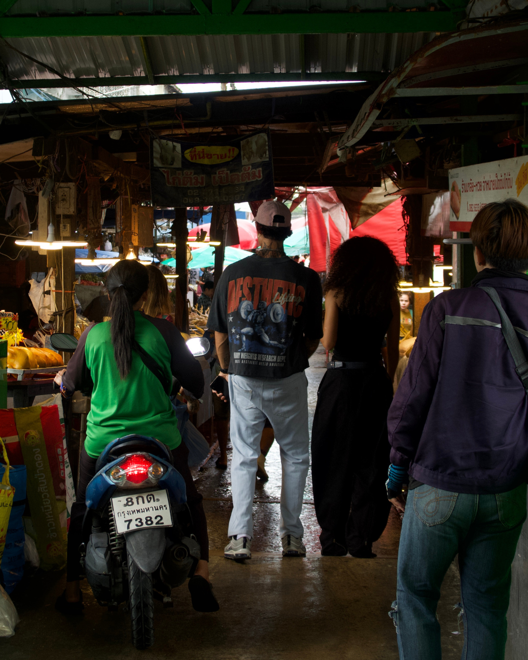 People walking through a Bangkok fruit market