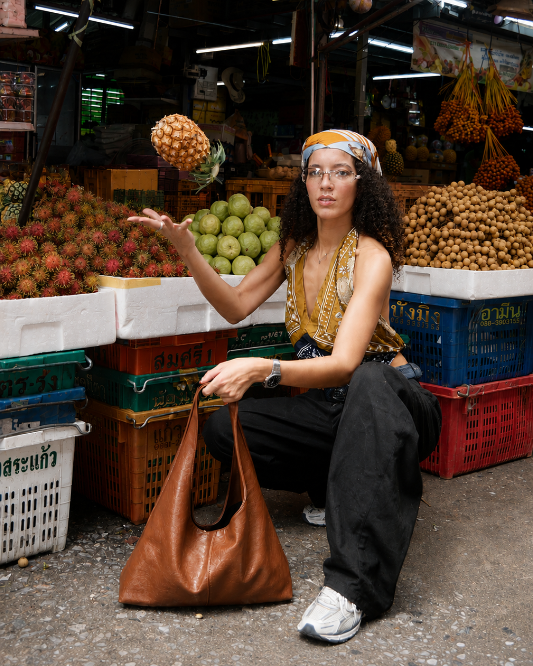 Campaign talent posing with pineapple among fruit-market stalls