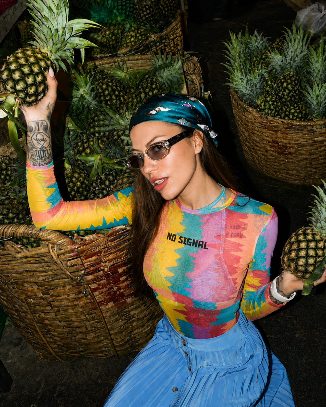 Campaign talent posing with pineapples at a market